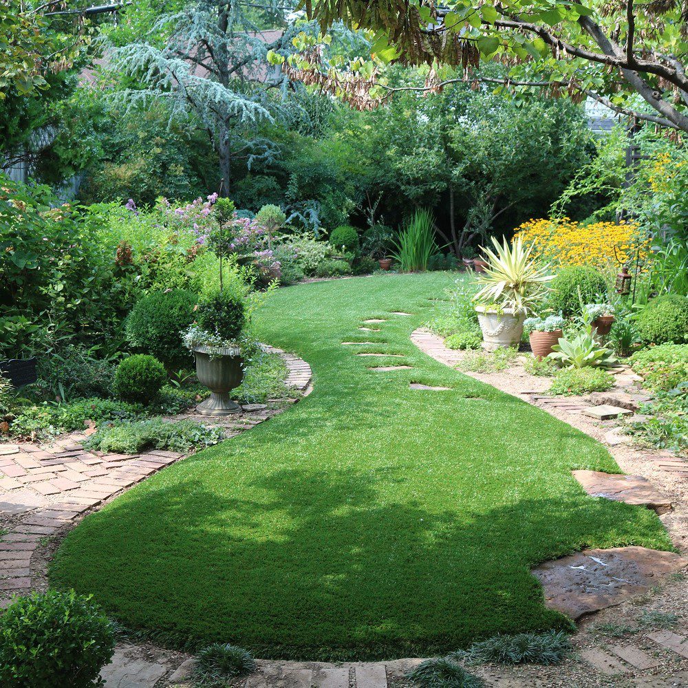 Artificial turf installation team working on residential lawn in Dallas TX